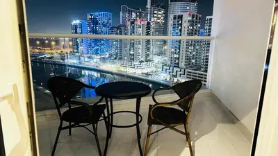 a table and chairs on a balcony with a view of the city at Phineek Homes Luxury Studio With Canal View Damac Maison Prive Business Bay in Dubai