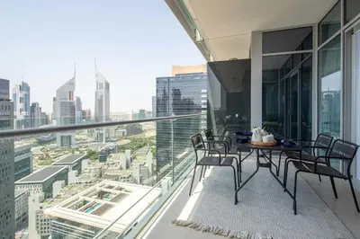 a balcony with a table and chairs and a city at Frank Porter - Burj Daman in Dubai