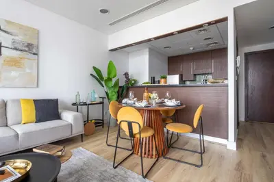 a kitchen and a living room with a table and chairs at Frank Porter - Burj Daman in Dubai