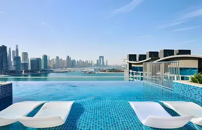 a swimming pool with two chairs and a city skyline at Seven Palm, Palm Jumeirah - Mint Stay in Dubai