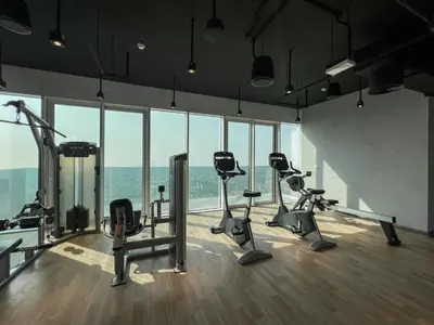 a gym with treadmills and exercise bikes in a room with windows at 2BR 1 Residences Zabeel with Sleeps 5 - Luxury Stay in Dubai