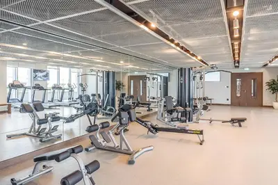 a gym with a lot of treadmills and exercise bikes at Your beachfront luxe escape experience - Suiteable in Dubai
