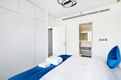 a bedroom with a bed with two towels on it at Modern Style 1 BR near Marina Mall and Metro in Dubai