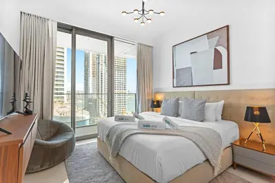 a bedroom with a bed with a chair and a large window at Palm View Paradise 3 bed apartment w private beach in Dubai