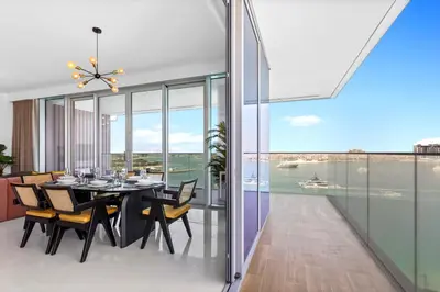 a dining room with a table and a view of the ocean at Palm View Paradise 3 bed apartment w private beach in Dubai