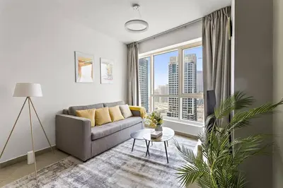 a living room with a couch and a large window at StoneTree - Unique 1BR Apartment in JLT in Dubai