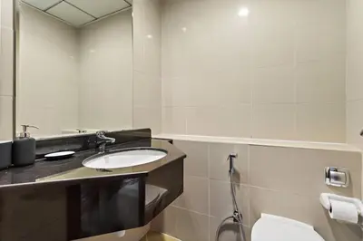 a bathroom with a sink and a toilet and a mirror at StoneTree - Unique 1BR Apartment in JLT in Dubai