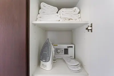 a closet with a microwave and towels on shelves at StoneTree - Unique 1BR Apartment in JLT in Dubai