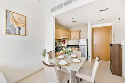 a kitchen and dining room with a table and chairs at StoneTree - Furnished 1BR with Canal View in Dubai