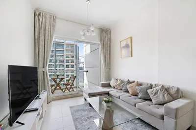 a living room with a couch and a television at StoneTree - Furnished 1BR with Canal View in Dubai