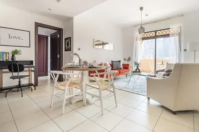 a kitchen and living room with a table and chairs at Frank Porter - Reehan 1 in Dubai