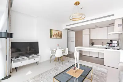 a kitchen with white cabinets and a table in a room at StoneTree - Fabulous 1BR Apartment in Dubai Marina in Dubai
