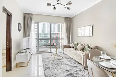 a white living room with a couch and a table at StoneTree - Modern 1 BR Apartment in Dubai Marina in Dubai