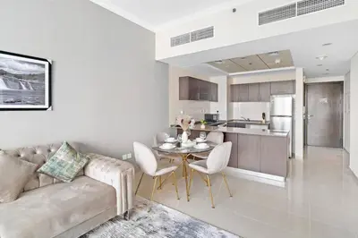 a living room with a couch and a table and a kitchen at StoneTree - Modern 1 BR Apartment in Dubai Marina in Dubai