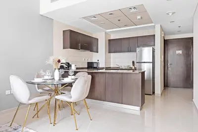a kitchen with a table and chairs and a refrigerator at StoneTree - Modern 1 BR Apartment in Dubai Marina in Dubai