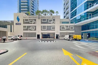 a parking lot in front of a large building at StoneTree - Modern 1 BR Apartment in Dubai Marina in Dubai