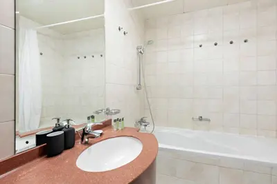 a bathroom with a sink and a bath tub at StoneTree - NEW Furnished 1BR in V3 Tower in Dubai
