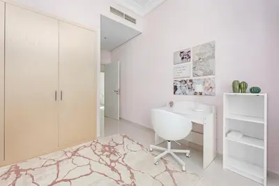 a white bathroom with a desk and a chair at StoneTree - The Modern Family Friendly Villa in Dubai