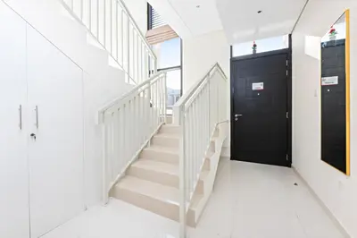 a hallway with stairs and a black door at StoneTree - The Modern Family Friendly Villa in Dubai