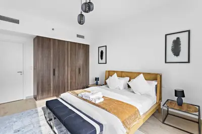 a bedroom with a large bed with a wooden headboard at StoneTree - Elegant 1 BR in Madinat Jumeirah Living Rahaal 2 in Dubai