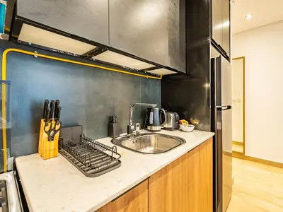 a kitchen with a sink and a refrigerator at Comfy and stylish Studio in Regina Towers - JVC in Dubai