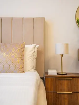 a bedroom with a bed and a lamp on a night stand at Comfy and stylish Studio in Regina Towers - JVC in Dubai