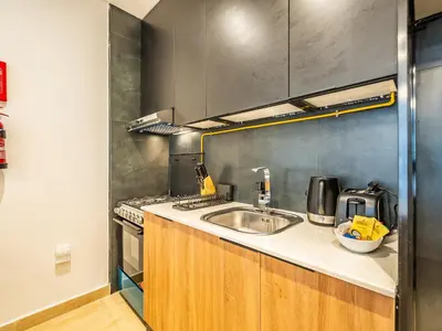 a kitchen with a sink and a stove at Comfy and stylish Studio in Regina Towers - JVC in Dubai