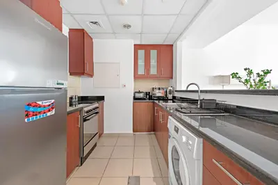 a kitchen with a sink and a dishwasher at Sleek Studio in JBR with Pool & Dubai Skyline View in Dubai