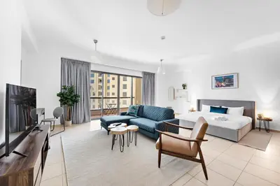 a large living room with a bed and a couch at Sleek Studio in JBR with Pool & Dubai Skyline View in Dubai