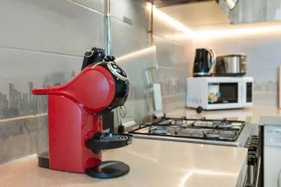 a red appliance sitting on top of a kitchen counter at StoneTree - Stylish 1BR Apartment in MBL Residence in Dubai