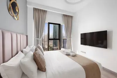 a bedroom with a large bed with a large window at StoneTree - Stylish 1BR Apartment in MBL Residence in Dubai