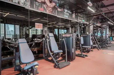 a gym with several rows of exercise bikes and weights at StoneTree - Stylish 1BR Apartment in MBL Residence in Dubai