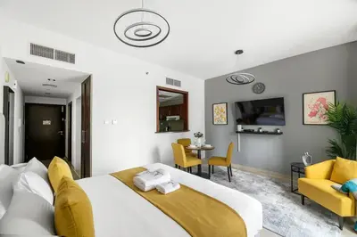 a bedroom with a bed and a table and chairs at StoneTree - NEW Furnished Studio in JLT in Dubai