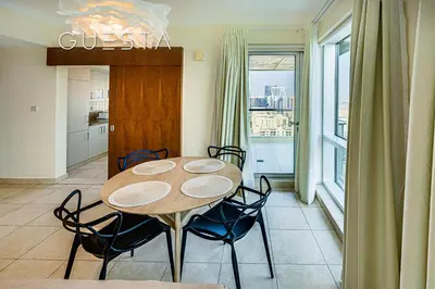 a dining room with a table and chairs and a window at Fairways Tower by Emaar, The Views and Greens in Dubai
