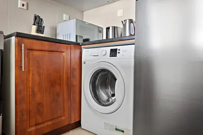 a kitchen with a washing machine and a refrigerator at StoneTree - NEW Modern 1BR in JLT in Dubai