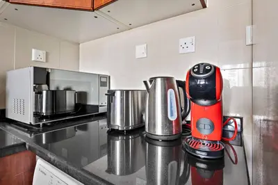 a red blender sitting on top of a kitchen counter at StoneTree - NEW Modern 1BR in JLT in Dubai