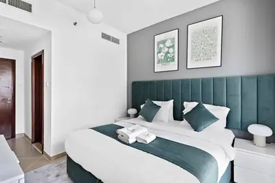 a bedroom with a large bed with a green headboard at StoneTree - NEW Modern 1BR in JLT in Dubai