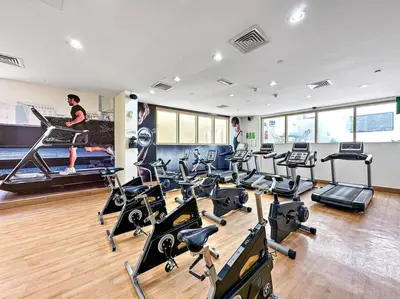 a gym with several treadmills and exercise bikes at StoneTree - NEW Modern 1BR in JLT in Dubai