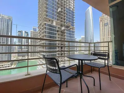 a balcony with a table and chairs and a view of a city at StoneTree - NEW Modern 1BR in JLT in Dubai