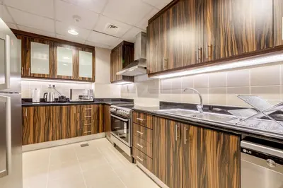 a large kitchen with wooden cabinets and a sink at GlobalStay 3 Bedroom Apartment near JBR Beach Dubai Marina in Dubai