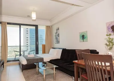 a living room with a couch and a table at StoneTree - Family-friendly Studio in Peaceful Community in Dubai
