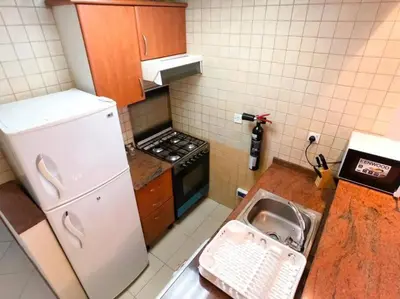 a kitchen with a sink and a white refrigerator at StoneTree - Prime Location - Furnished Studio - Near Metro in Dubai
