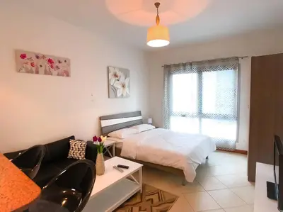 a bedroom with a bed and a living room with a couch at StoneTree - Prime Location - Furnished Studio - Near Metro in Dubai