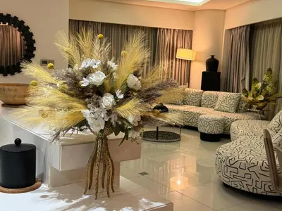 a living room with a vase of flowers on a table at ROYAL APARTMENTS By Damac Paramount Towers B Burj Khalifa Views in Dubai