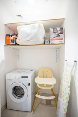 a laundry room with a washing machine and a stool at Azure Escape !Joyful 1 Bed Apartment close to the Sea! in Dubai