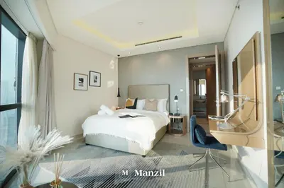 a bedroom with a white bed and a large window at Manzil - Stunning 3BR Apt in Paramount nr Burj in Dubai