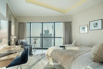 a bedroom with a bed and a desk and a window at Manzil - Stunning 3BR Apt in Paramount nr Burj in Dubai