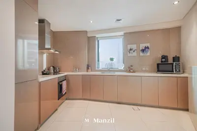 a large kitchen with a sink and a microwave at Manzil - Stunning 3BR Apt in Paramount nr Burj in Dubai