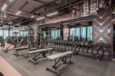 a gym with rows of dumbbells and weights at StoneTree - Modern 1BR with Amazing Building Facilities in Dubai