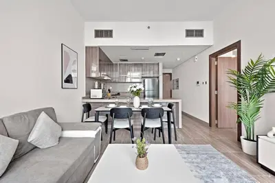 a living room and kitchen with a couch and a table at StoneTree - Modern 1BR with Amazing Building Facilities in Dubai